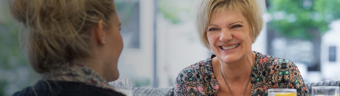 Margit, Anwenderin von SenSura Mio, genießt gemeinsam mit einer Freundin ihr Mittagessen.