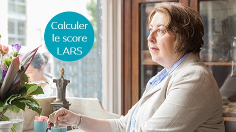 Femme devant une fenêtre regardant dehors avec un insert : Calculer le score LARS 